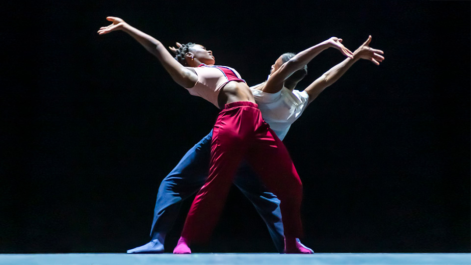 2 dancers on a black stage.