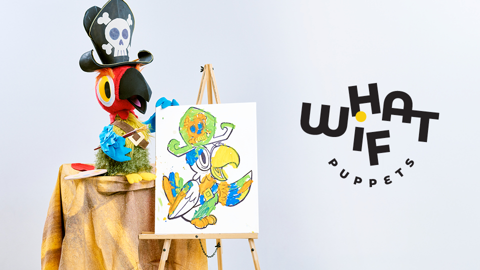 A parrot puppet and a parrot drawing next to the logo for What If Puppets