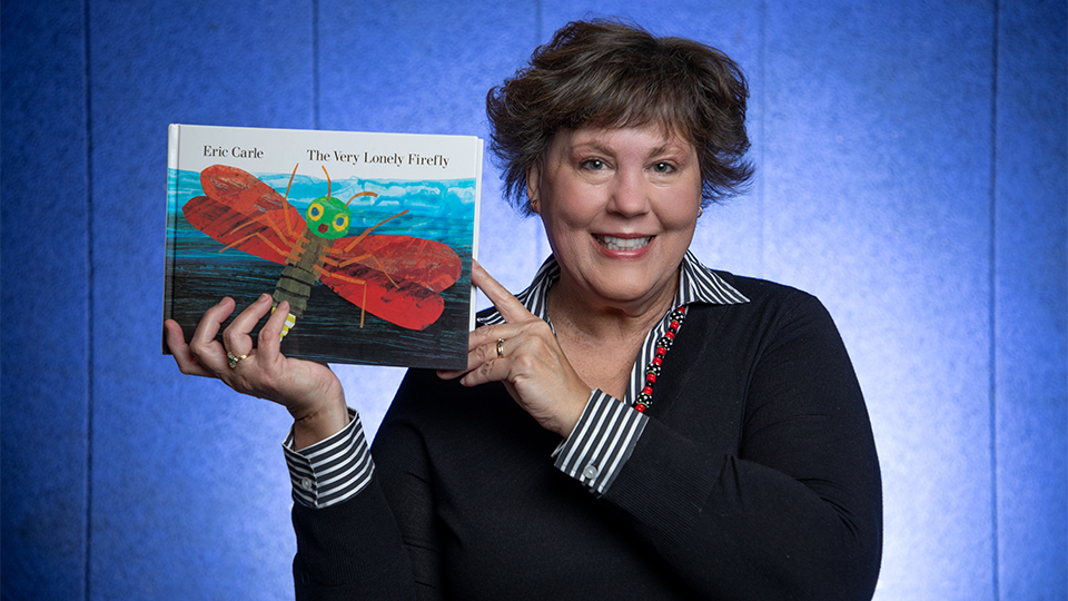 Kim Ratliff holding up the book The Very Lonely Firefly by Eric Carle