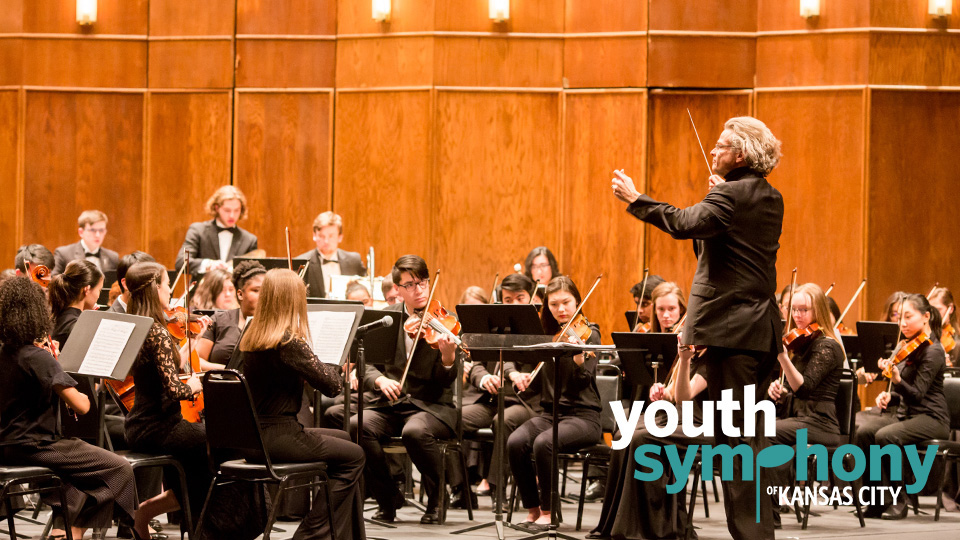 Youth Symphony of Kansas City performing on a stage with the words Hear the Future Now and the logo for Youth Symphony of Kansas City