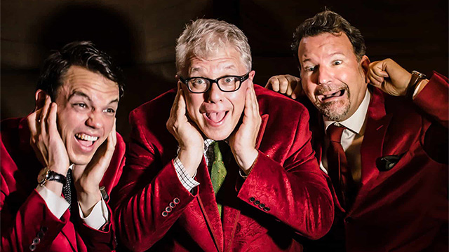 Three men in red velvet suits making funny faces with their fingers in their ears