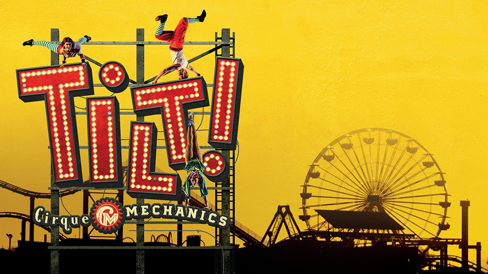 Ferris wheel next to a large fair sign that says Tilt