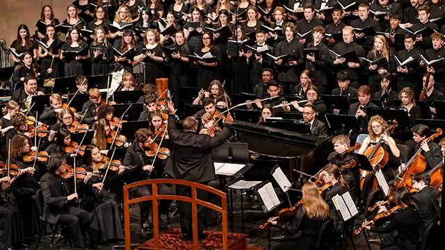 The KU orchestra and combined choirs performing on stage