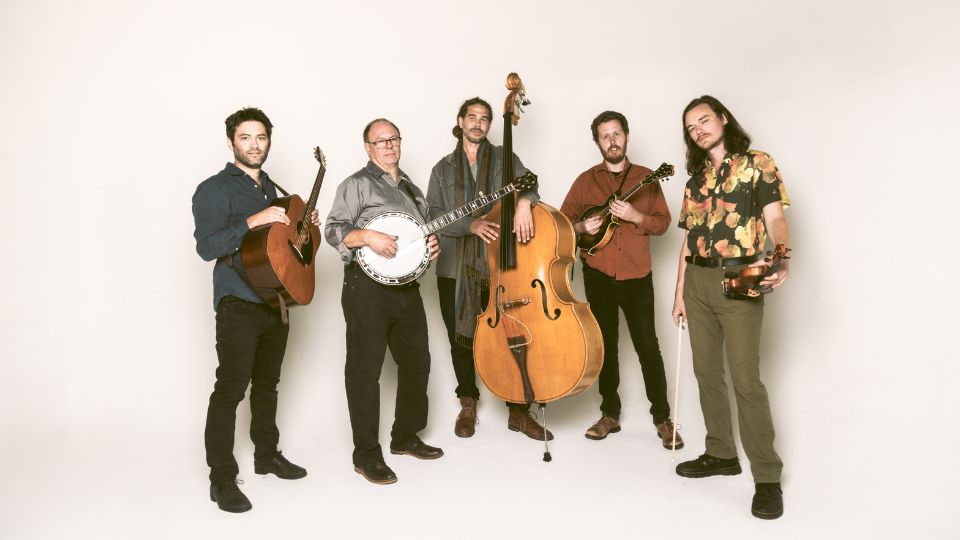 five musicians in a line who are each holding the instrument they play