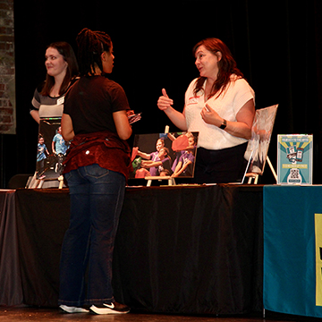 A representative from TeenTix KC talks to an area art teacher at the Creative Connection event