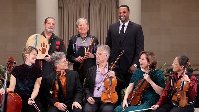 8 musicians holding their instruments and smiling