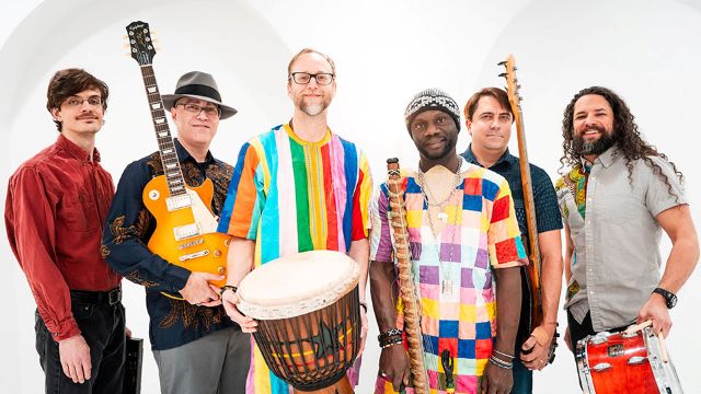 the six members of Kaira Ba standing in a line with their instruments