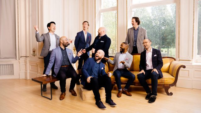 8 members of Cantus smiling and laughing together