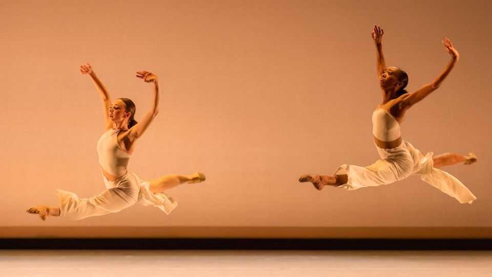 two dancers performing the same jump