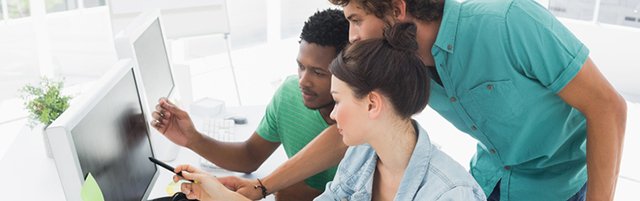 Two men and a woman look at a computer screen.