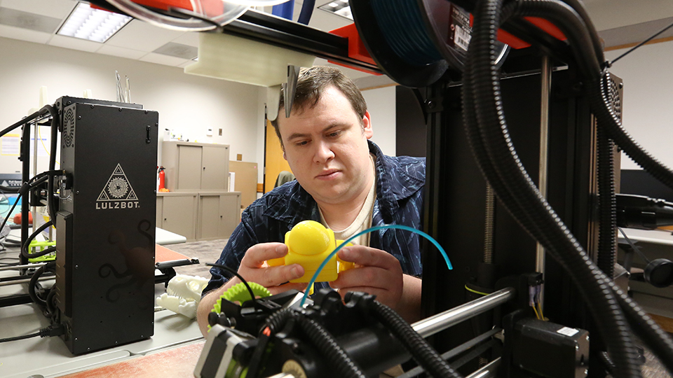 Student using the 3D printer in the MakerLab