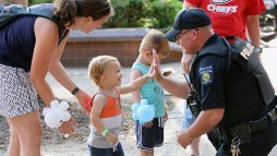 Police officer chatting with young children visiting campus