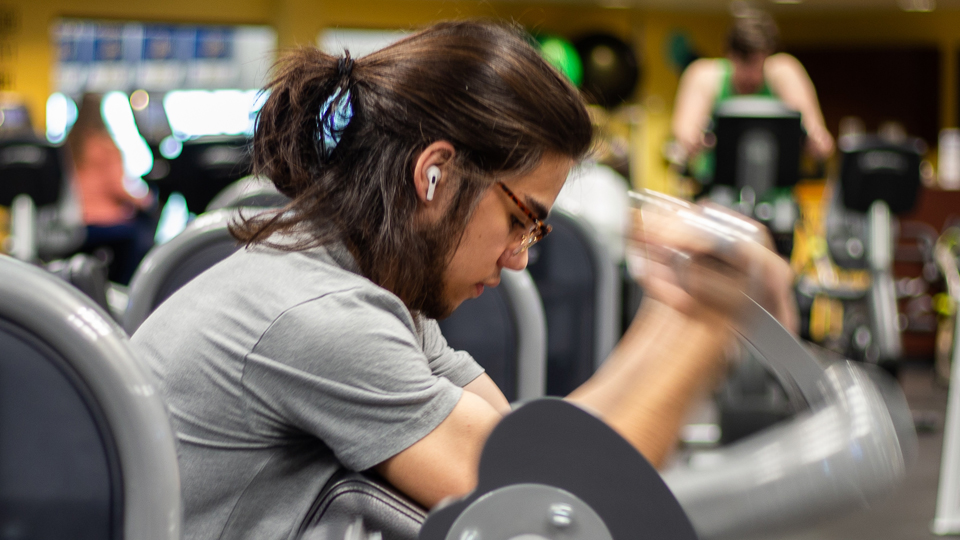 Close-up of student doing curls in the Fitness Center