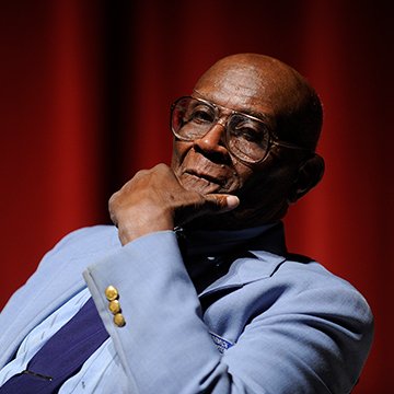 Tuskegee Airman sitting on a chair on a stage