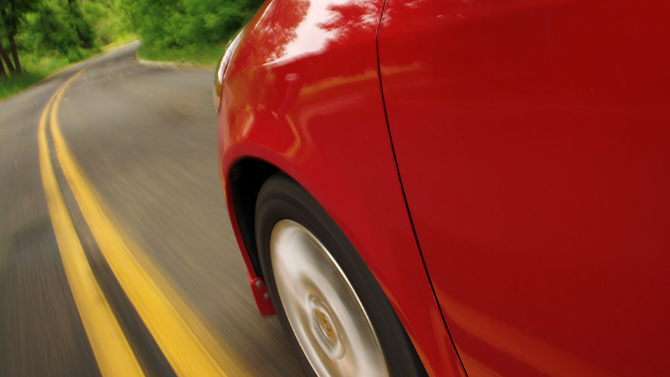 A close up of the driver's side front wheel of a red car.