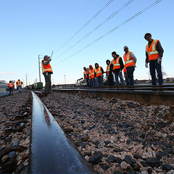 An instructor addresses students in a rail yard.
