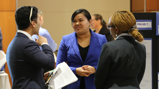 Three JCCC students conversing at a reverse career fair.